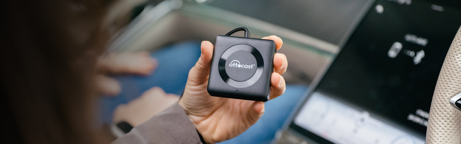 OTTOCAST Mini 2-in-1 wireless CarPlay/Android Auto adapter held in hand, thumb-drive sized and USB stick-like