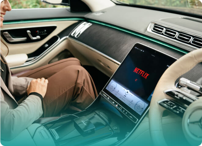 Passenger watching Netflix on car screen using Ottocast Play2Video Pro wireless CarPlay Android Auto adapter